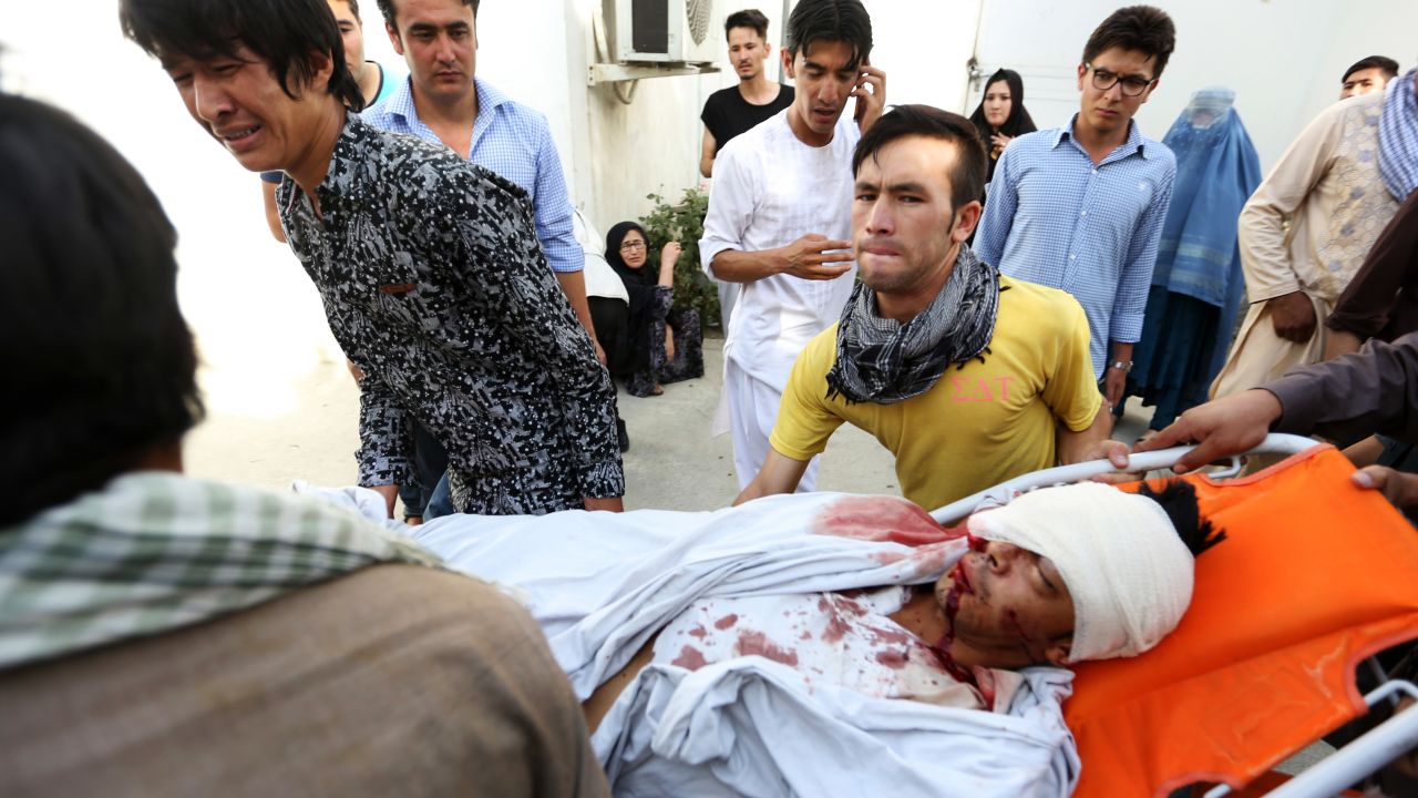 Afghans help a man who was injured in the deadly explosion.