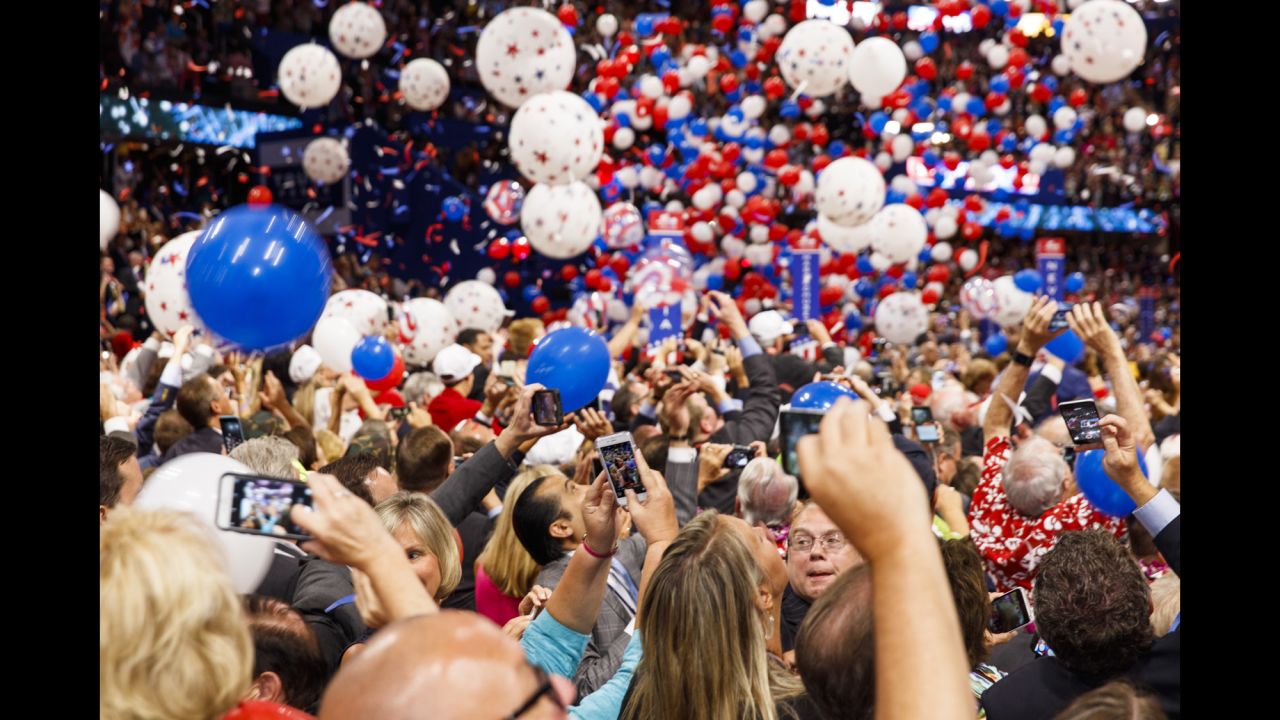 Delegates take photos and watch as balloons drop at the end of the convention.