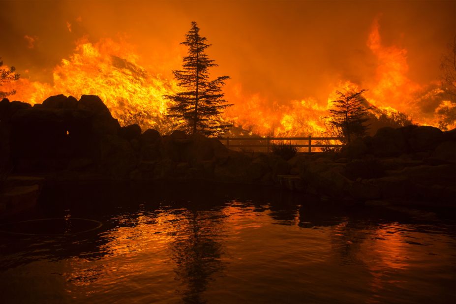 Flames from the Sand Fire are reflected in a backyard swimming pool on Saturday in Santa Clarita.<br />