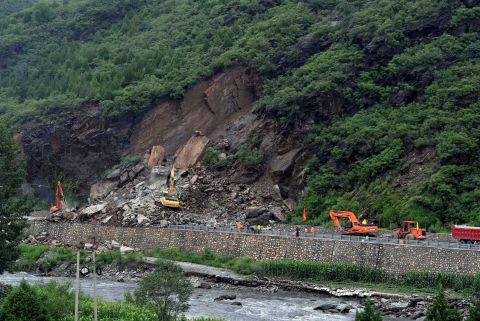 This photo taken on July 21, 2016 shows workers repairing a damaged road hit by heavy rainstorms in Fangshan District in Beijing.