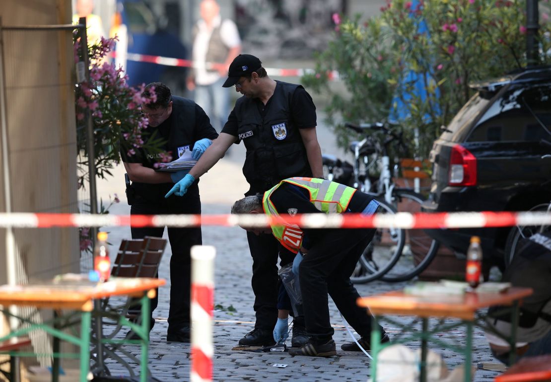 Police officers conduct an investigation on Monday, following a suicide bombing in Ansbach, Germany.