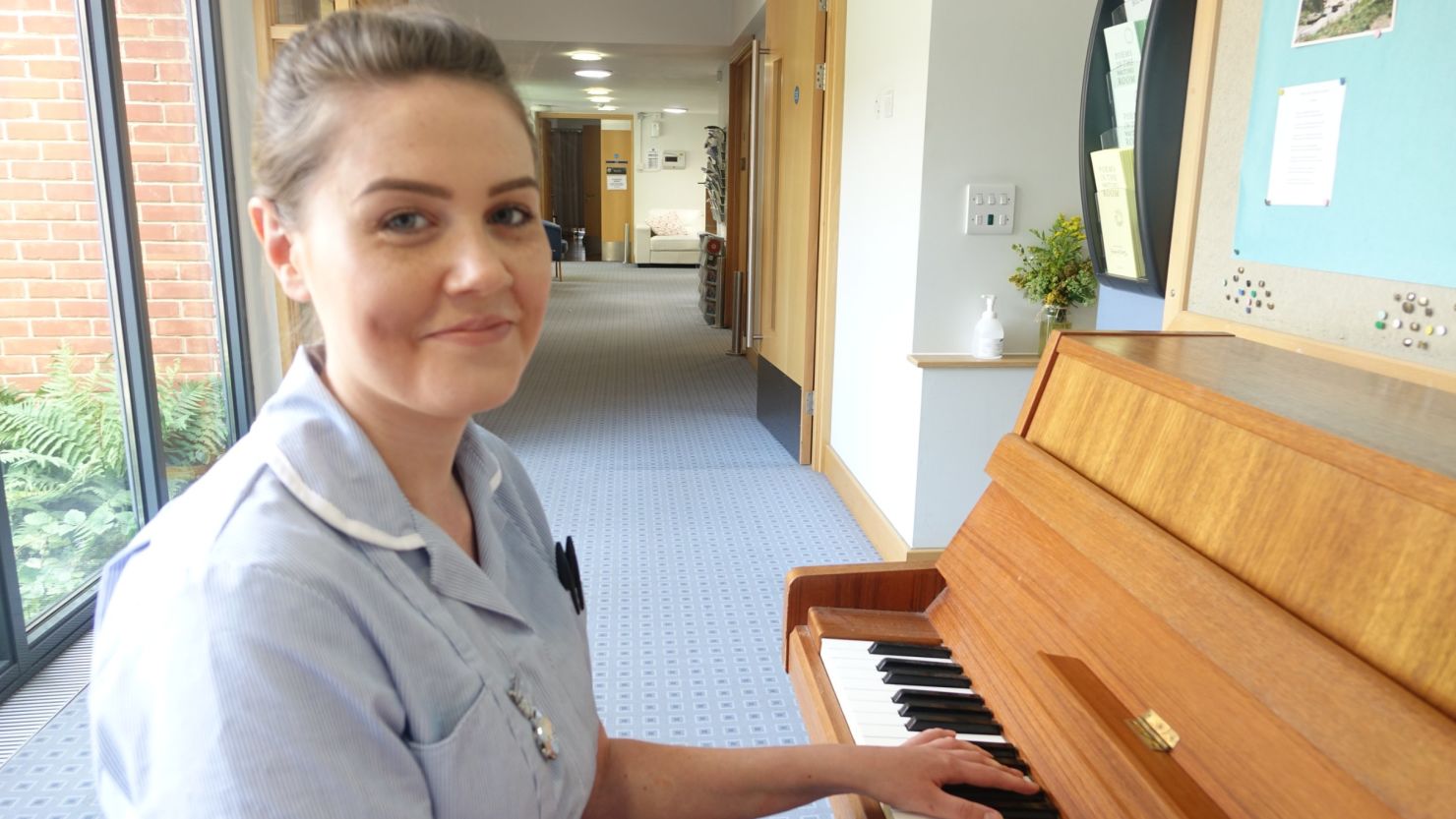 St. Helena Hospice nurse's assistant Emma Young with the piano from the video. 