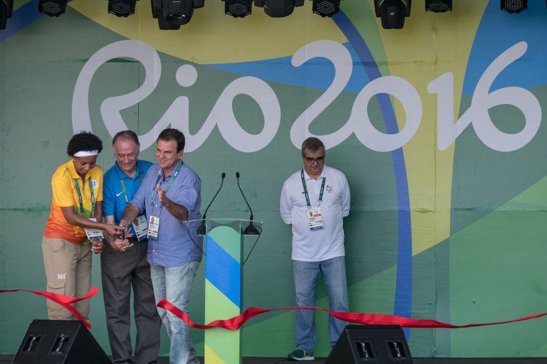 Rio de Janeiro Mayor Eduardo Paes (right, blue shirt) helps cut the ribbon during the opening ceremony of the Olympic Village on July 24.