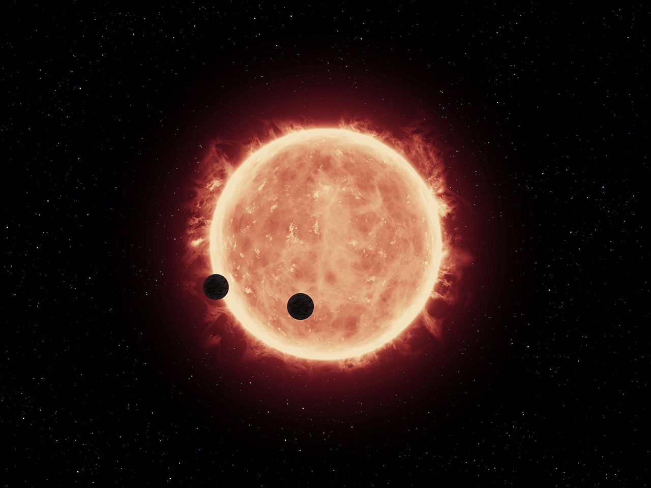 An artist's rendering shows Earth-sized exoplanets TRAPPIST-1b and 1c in a rare double transit event as they pass in front of their ultracool red dwarf star, which allowed Hubble to take a peek at at their atmospheres. 