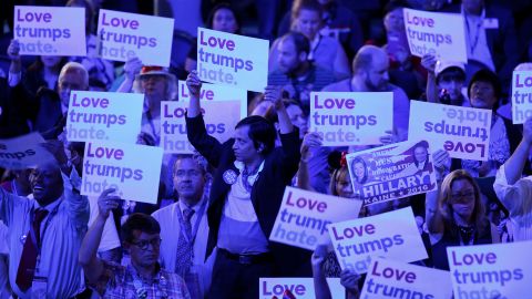 Delegates hold signs reading "Love trumps hate" on Monday.