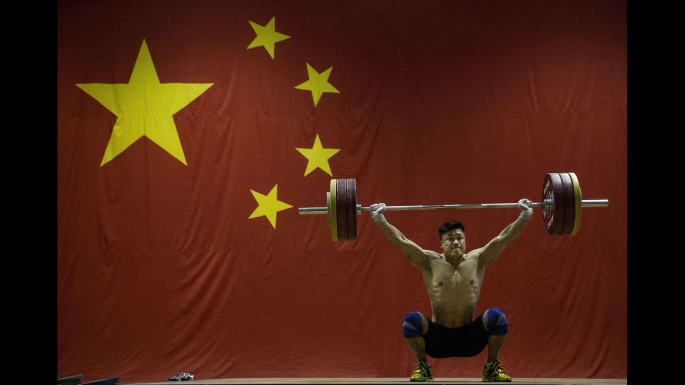Chinese weightlifter Lu Xiaojun trains in Beijing on Friday, July 22. He won Olympic gold four years ago.