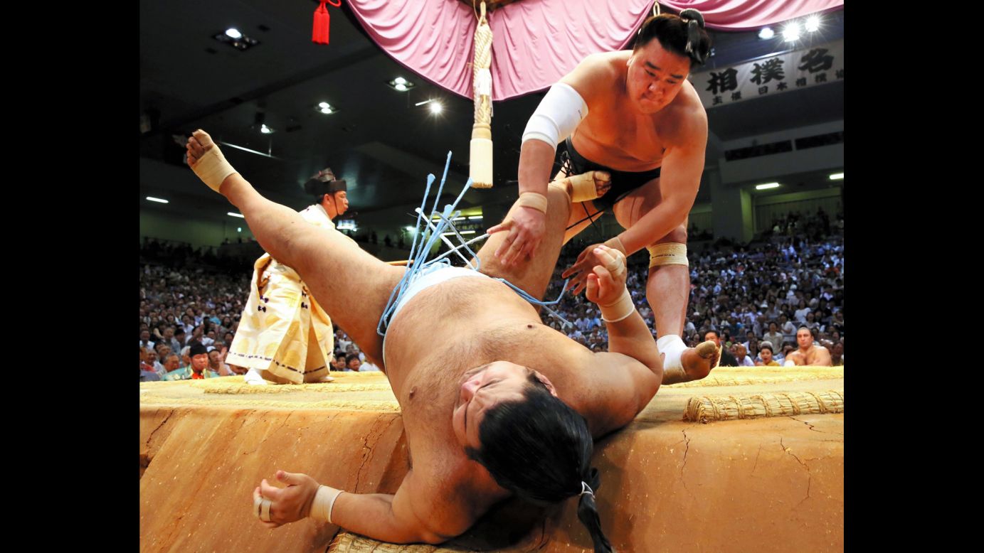 Harumafuji throws Takayasu during the Grand Sumo Tournament in Nagoya, Japan, on Tuesday, July 19. Harumafuji would go on to win the tournament.