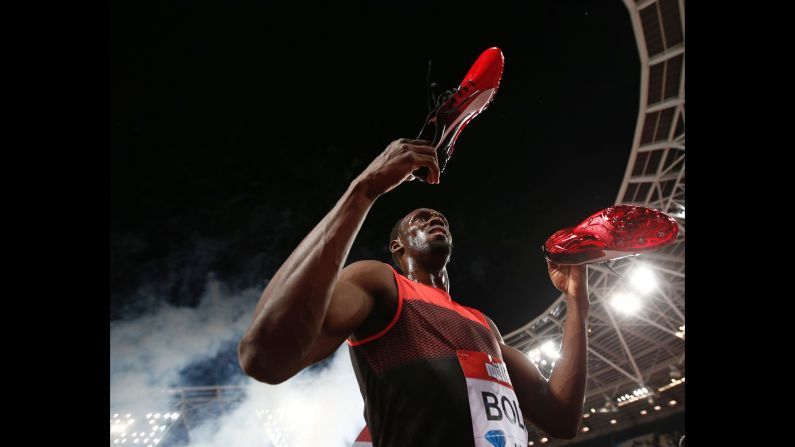 Jamaica's Usain Bolt holds out his spikes as he interacts with spectators after winning the men's 200m at the IAAF Diamond League Anniversary Games athletics meeting at the Queen Elizabeth Olympic Park stadium in Stratford, east London on July 22, 2016.