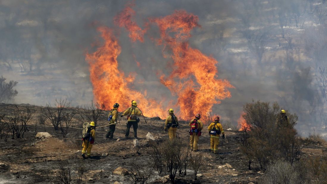 Firefighters monitor a flareup as they work to stop the advance of the Sand Fire near the town of Acton, California. 