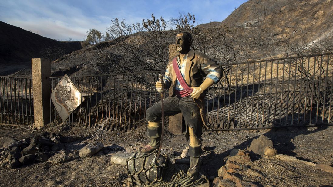 A burned pirate sculpture stands in the charred landscape in Santa Clarita.