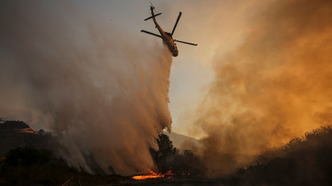 A helicopter makes a drop on a wildfire near Placerita Canyon Road in Santa Clarita on Sunday. 