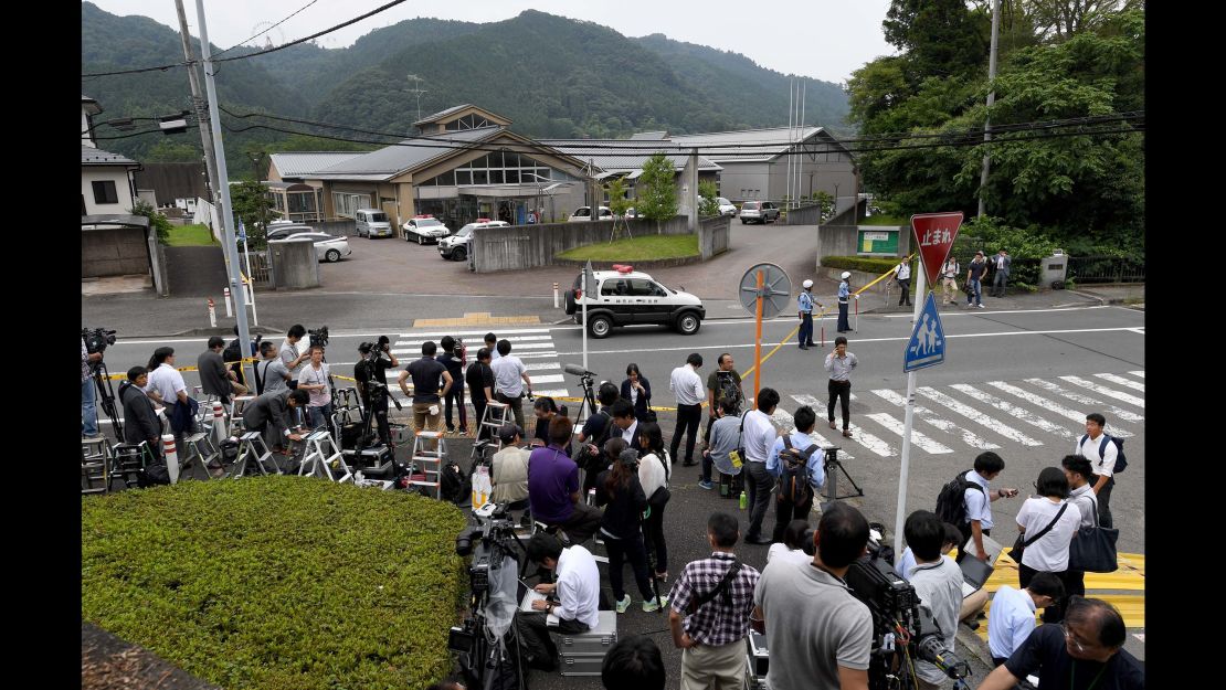Journalists gather at the main gate of the Tsukui Yamayuri-en care center