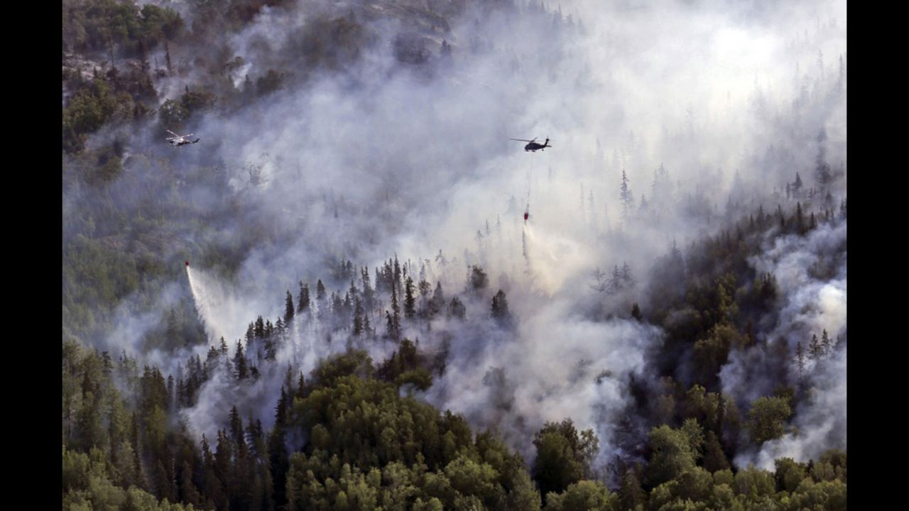 Helicopters with the Alaska Army National Guard and Alaska's Division of Forestry dump water onto the McHugh Creek wildfire near Anchorage, Alaska, on Wednesday, July 20.