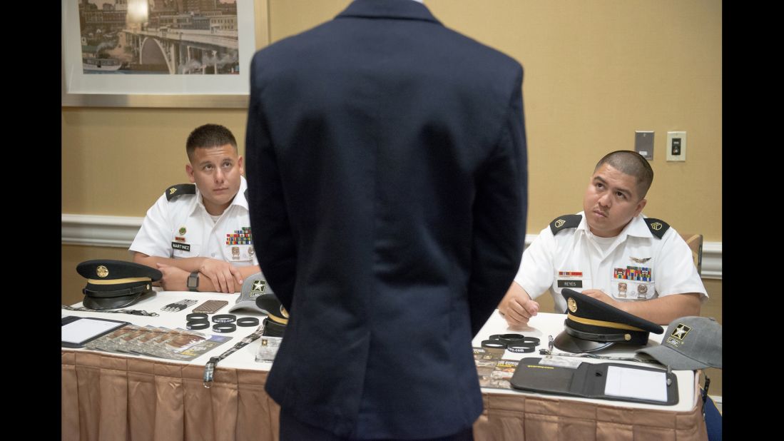 U.S. Army recruiters speak to a job-seeker during a career fair in Houston on Thursday, July 7.