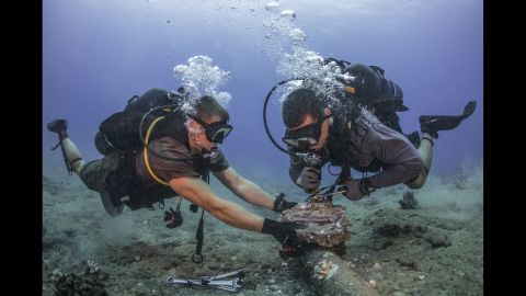 U.S. Navy construction mechanic Andersen Gardner, left, and chief construction electrician Daniel Luberto remove corroded zinc anodes from an undersea cable at the Pacific Missile Range Facility in Hawaii on Tuesday, July 5.