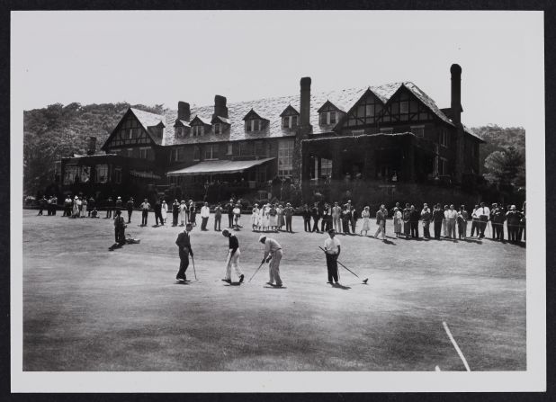 Players practice putting in front of the clubhouse in 1936. Originally a converted barnhouse -- the course was built on a farm -- it burned down in 1909 and was rebuilt in a Tudor revival style.