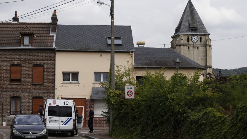 Police officers stand on guard behind the church of Saint-Etienne-du-Rouvray on July 26, 2016, following an attack by two knife-wielding men.
The Islamic State group said on July 26 that the two assailants who stormed a church in France and killed an elderly priest were its "soldiers,". They stormed the church during morning mass, taking the five people inside hostage and slitting the throat of its priest Jacques Hemel, who was in his eighties. The attackers were killed by police after they emerged from the church when it was surrounded by France's anti-gang brigade, the BRI, which specialises in kidnappings.
/ AFP PHOTO / CHARLY TRIBALLEAUCHARLY TRIBALLEAU/AFP/Getty Images