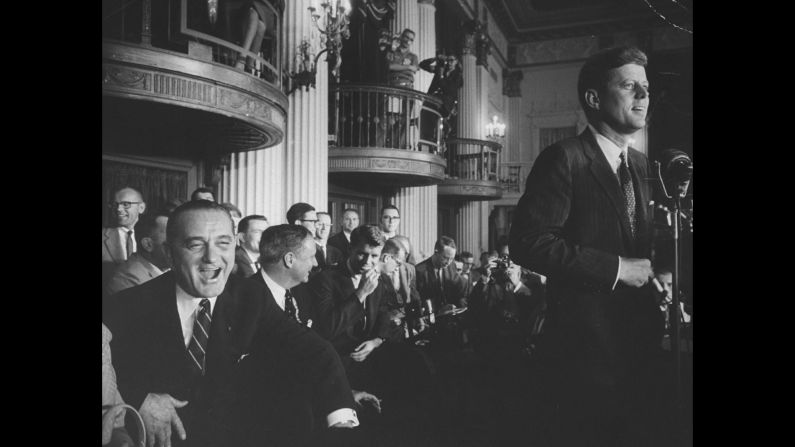 Johnson, left, and Robert F. Kennedy, center, share a laugh during remarks by John F. Kennedy.<br />