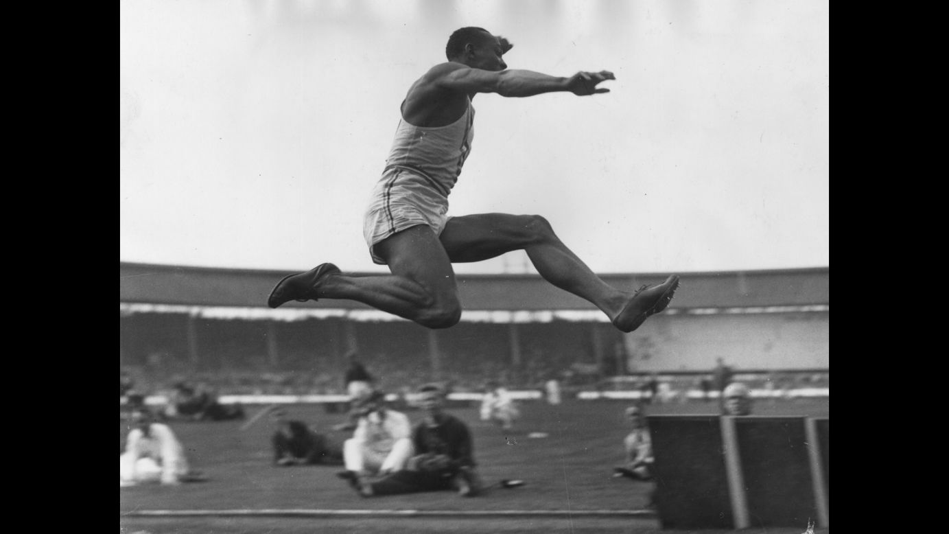 Owens takes part in a long-jump event in London in August 1936.