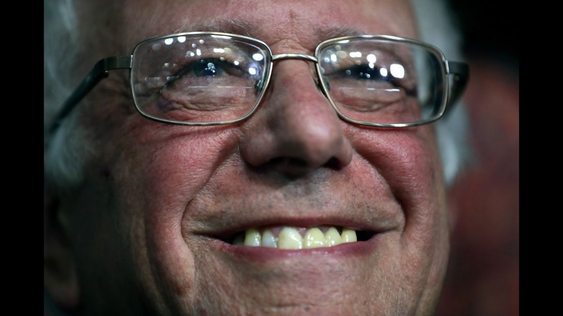 Sanders smiles while attending roll call. He moved to name Clinton the official nominee.