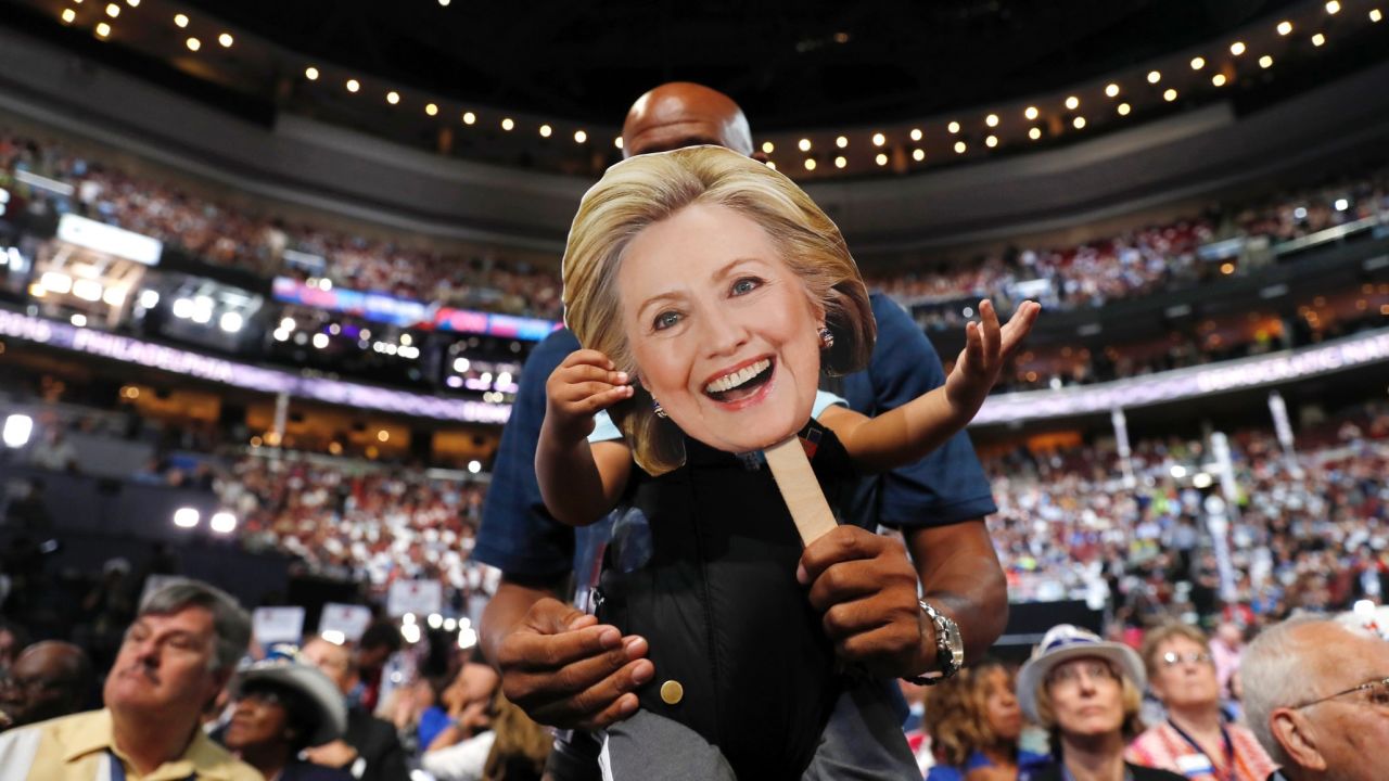 Florida delegate Bernard Jennings holds a cardboard cutout of Hillary Clinton over the face of his young son Ethan on Tuesday.