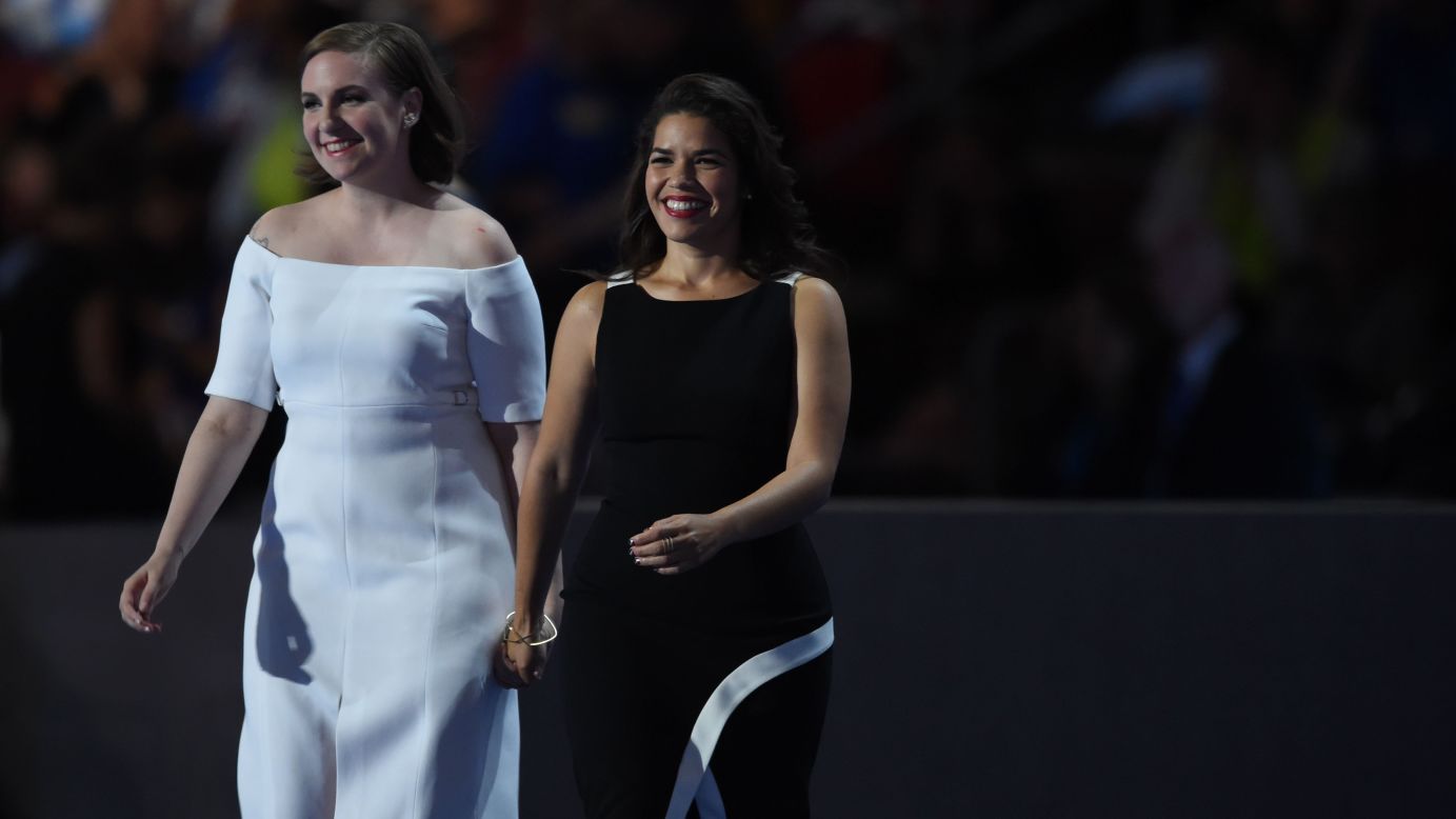Actresses America Ferrera, right, and Lena Dunham walk on stage to deliver remarks.