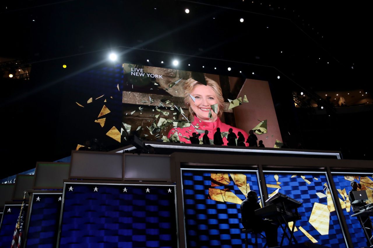 Clinton appears live on a video screen Tuesday night. Just a few hours earlier, she officially became the party's presidential nominee. She is the first woman to lead a major party's presidential ticket. "I can't believe we just put the biggest crack in that glass ceiling yet," she told the crowd.