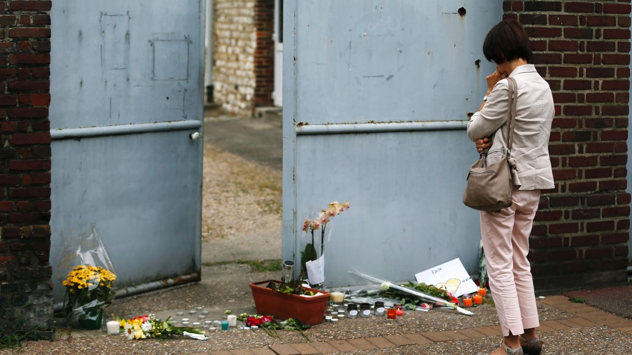 A woman mourns in front of the house of Father Jacques Hamel on July 27, 2016 in Saint-Etienne-du-Rouvray, where the priest was killed the day before in the latest of a string of attacks against Western targets claimed by or blamed on the Islamic State jihadist group.