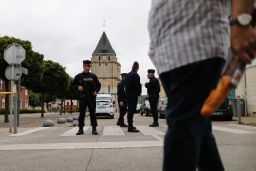 Police officers stand guard at the Saint-Etienne church.