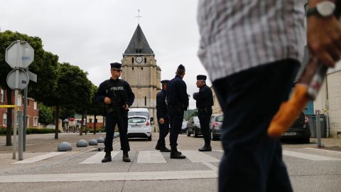 Police officers stand guard at the Saint-Etienne church.
