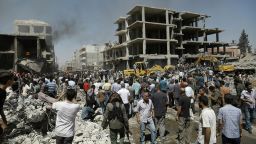 Syrians gather at the site of a bomb attack in Syria's northeastern city of Qamishli on Wednesday, July 27. A double bomb attack killed at least 14 people including civilians and left dozens wounded in a Kurdish-majority city in northeast Syria, the Syrian Observatory for Human Rights said.
