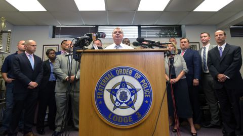 Gene Ryan, center, flanked by attorneys and accused police officers.