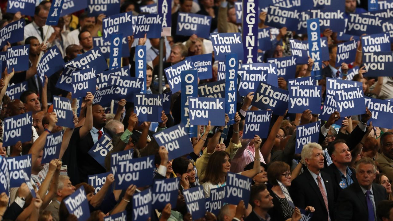Delegates stand as US President Barack Obama speak on the third day of the Democratic National Convention at the Wells Fargo Center, July 27, 2016 in Philadelphia, Pennsylvania. Democratic presidential candidate Hillary Clinton received the number of votes needed to secure the party's nomination. An estimated 50,000 people are expected in Philadelphia, including hundreds of protesters and members of the media. The four-day Democratic National Convention kicked off July 25.