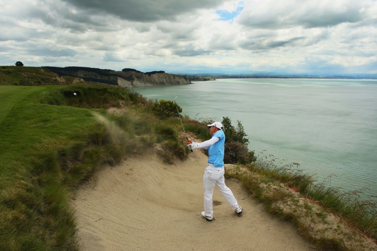 Doak's other top-100 course is Cape Kidnappers in New Zealand, set on the rugged Hawke's Bay coast. Here American golfer Anthony Kim plays out of a bunker during a 2009 tournament. 