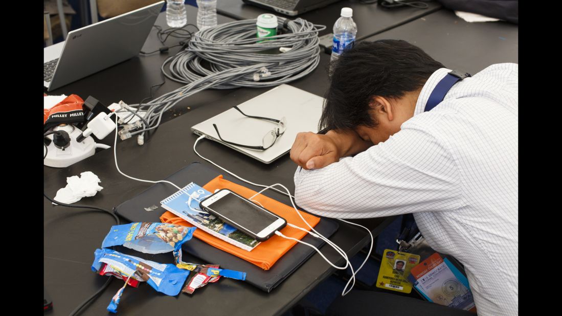 A journalist from The Hankyoreh, a South Korean newspaper, rests in the media pavilion.