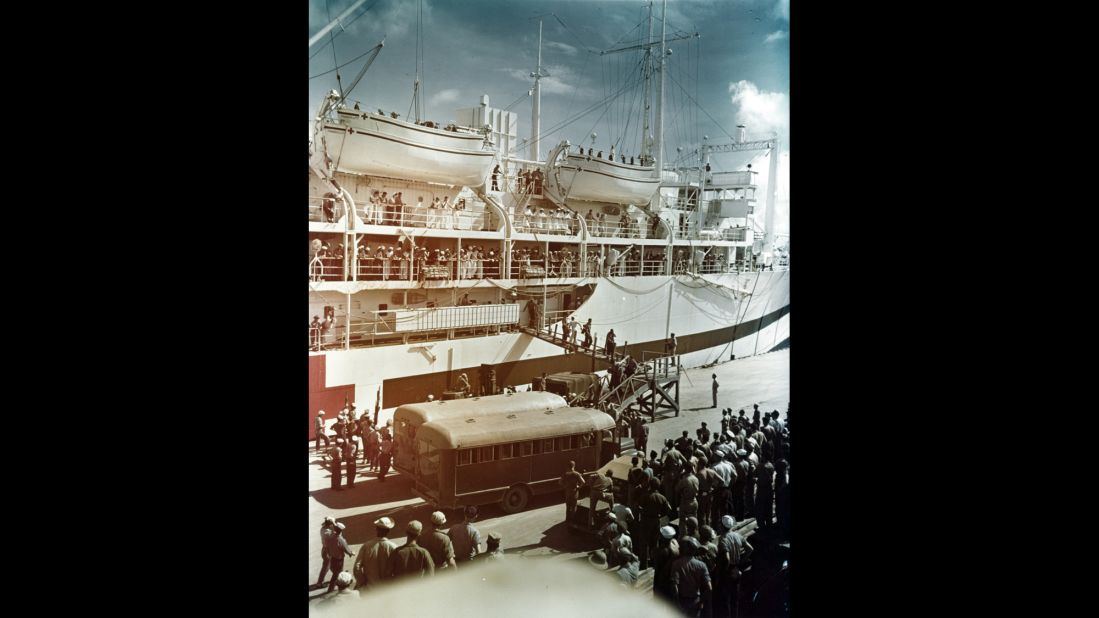 Survivors are brought ashore from the USS Tranquillity at Guam on August 8, 1945. Nurses and sailors watch from the hospital ship's deck. The Indianapolis crew had hoped for a quick rescue, but the vessel wasn't reported missing for several days after it sank.