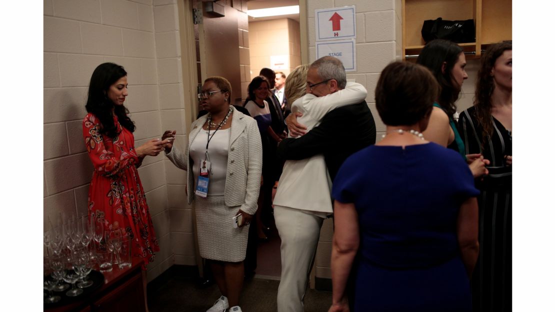 Backstage after accepting the presidential nomination, Clinton embraces campaign chairman John Podesta as another top aide, Huma Abedin, stands nearby.