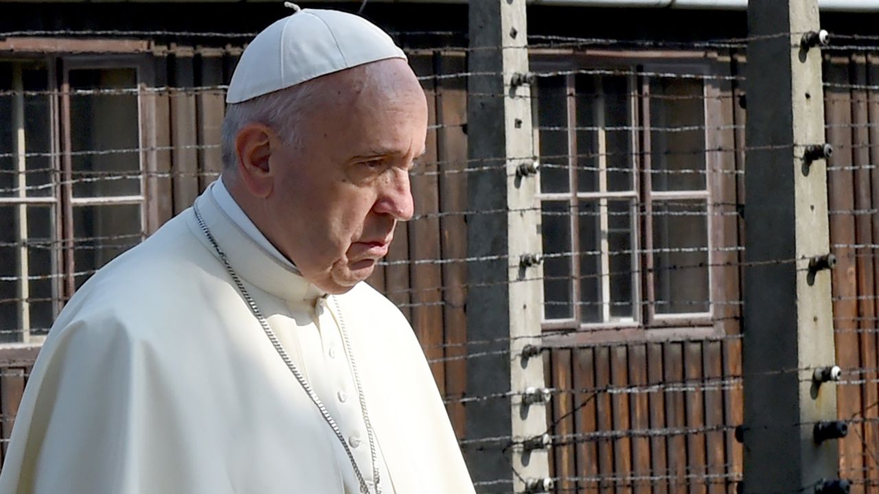 Pope Francis walks through the entrance of the former Nazi death camp of Auschwitz in Oswiecim, Poland on 29 July, 2016.
Pope Francis is in Poland for an international Catholic youth festival with a mission to encourage openness to migrants.