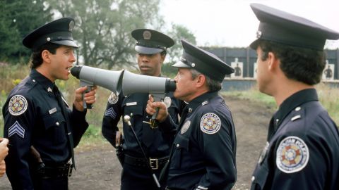 Steve Guttenberg as Mahoney and G.W. Bailey as Captain Harris in conversation while Michael Winslow looks on in a scene from a "Police Academy" film.