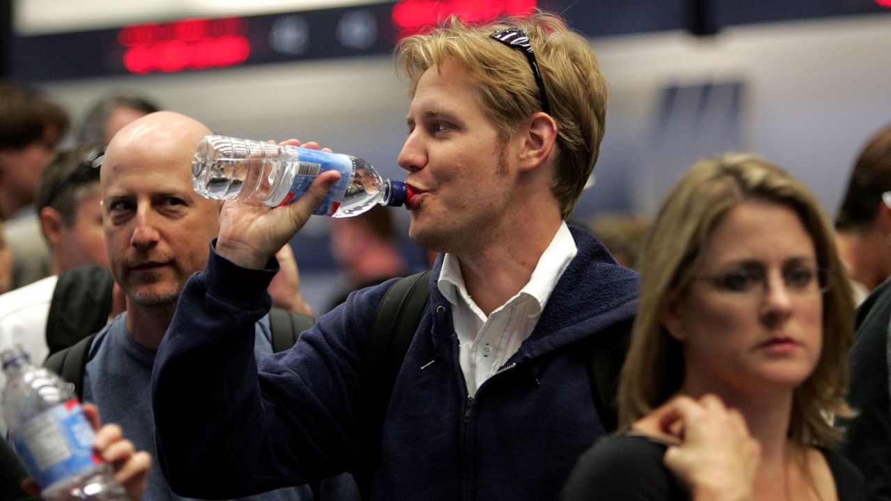 SAN FRANCISCO - AUGUST 10: A United Airlines passenger takes a sip of water before throwing away the bottle at a security checkpoint at San Francisco International Airport August 10, 2006 in San Francisco. The Department of Homeland Security raised the terrorism alert to Red, the highest level for commercial flights from Britain to the United States. The U.S. government banned all liquids and gels from flights effective immediately. (Photo by Justin Sullivan/Getty Images)