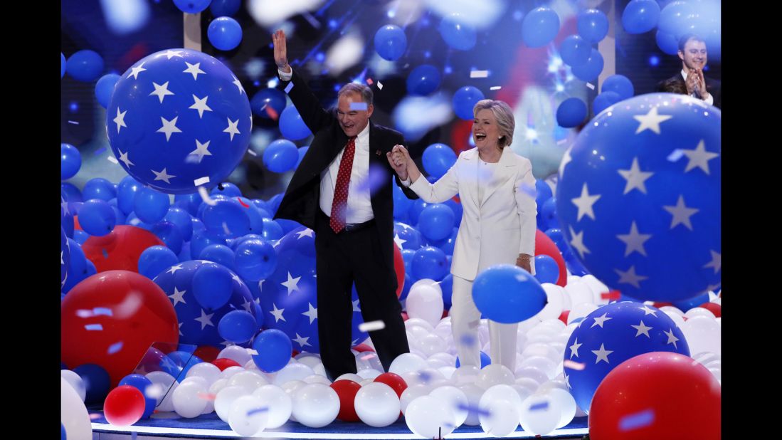 Democratic presidential nominee Hillary Clinton walks through balloons with her running mate, U.S. Sen. Tim Kaine, at the end of the Democratic National Convention on Thursday, July 28.