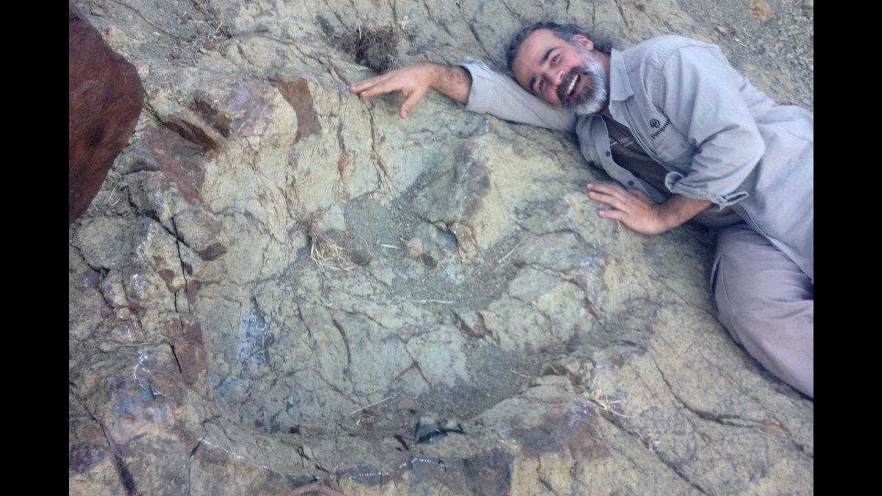 Paleontologist Sebastian Apesteguia lies next to a newly discovered dinosaur footprint in Bolivia.