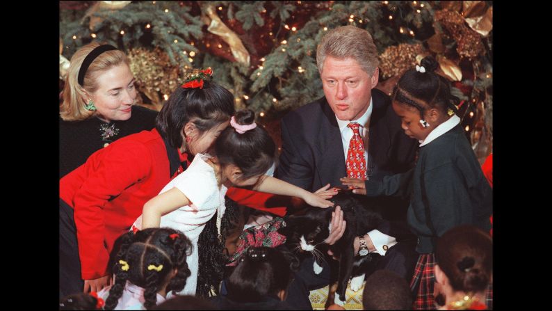 Former President Bill Clinton and First Lady Hillary Clinton, along with Socks, spent time with children during a Christmas gathering at the White House in 1996. <br />