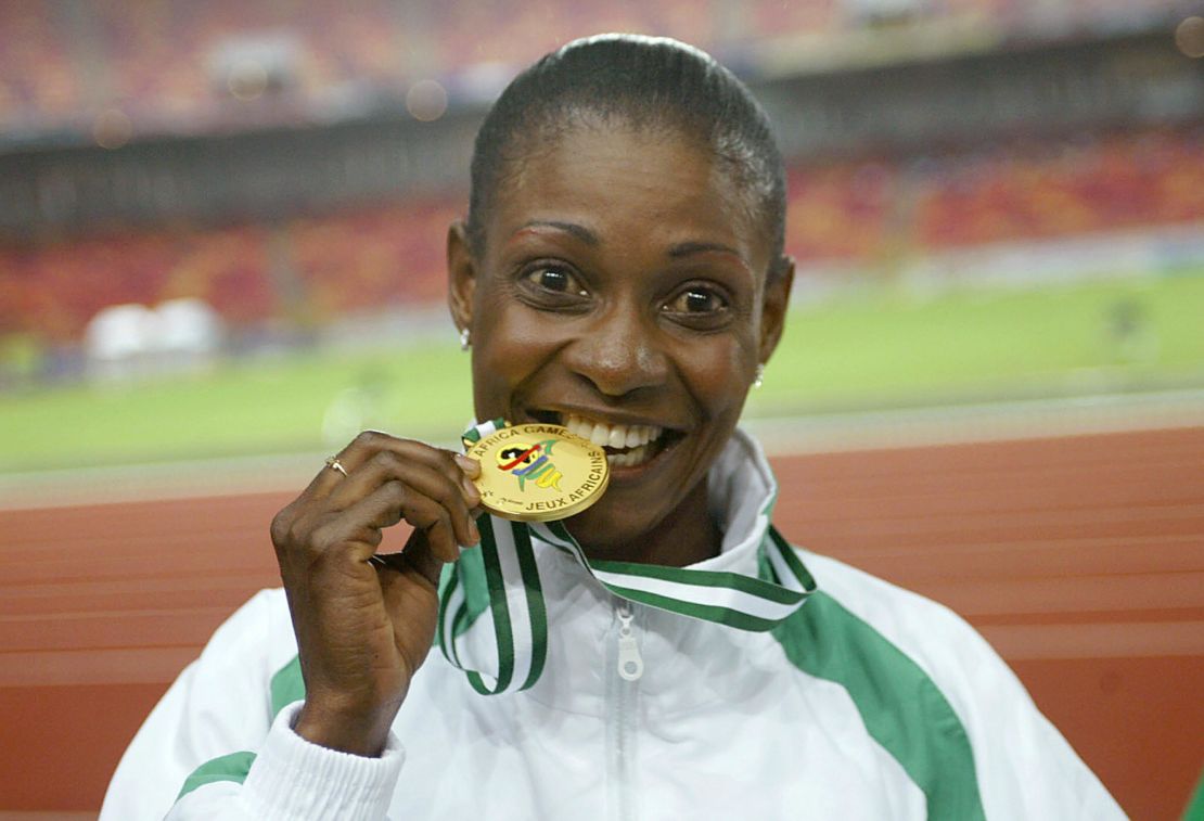 Mary Onyali-Omagbemi bites her gold medal in  October, 2003, after receiving her medals at the 8th All African Games in Abuja. 