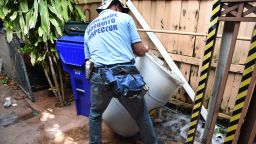 Miami-Dade mosquito control worker Carlos Vargas dumps a barrel of standing water that can incubate the Aedes aegypti mosquito larvae at a home in Miami, Florida, on June 08, 2016. 
Of the forty different types of mosquito found in Miami -Dade the Aedes aegypti mosquito or yellow fever mosquito is responsible for transmitting diseases such as the Zika Virus.  / AFP / RHONA WISE / TO GO WITH AFP STORY by Leila MACOR, "Florida health warriors deploy in war on Zika"        (Photo credit should read RHONA WISE/AFP/Getty Images)