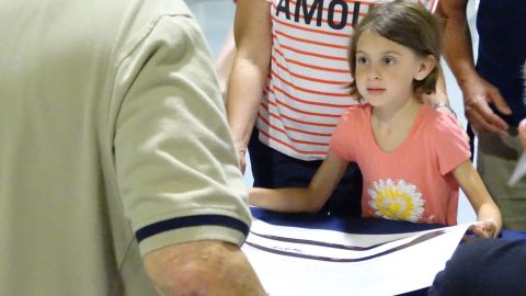 A young visitor at Saturday's event asks an ex-crew member to sign her Blackbird poster. 