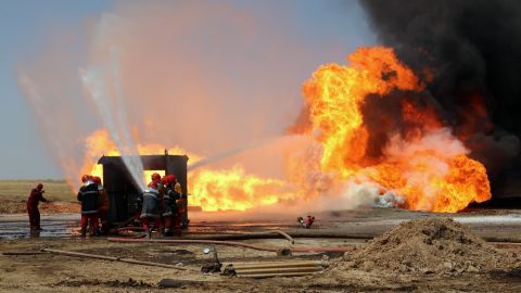 Oil workers and firemen try to extinguish flames at the Khabbaz oil field  near Kirkuk on June 1 after an attack.