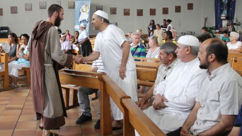A Catholic monk welcomes Muslims to a mass in Nice, France, where people gathered to mourn a priest slain by jihadists.