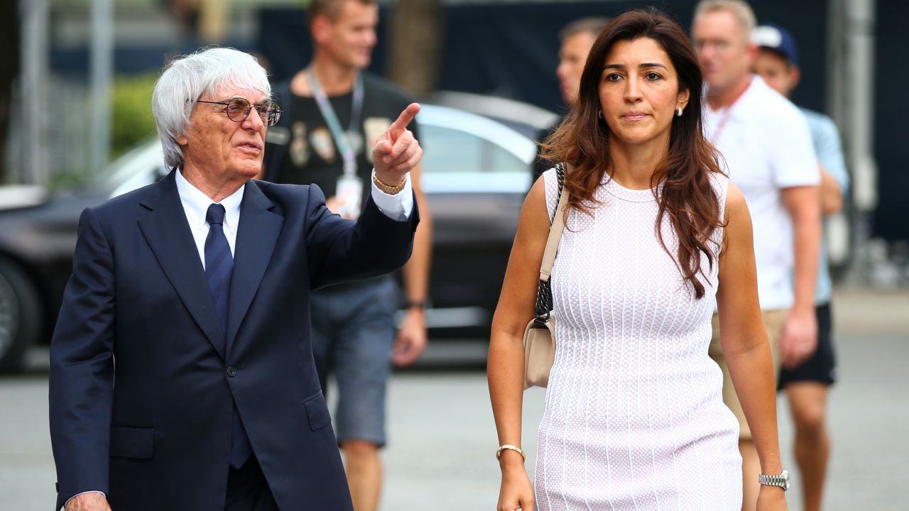 F1 chief Bernie Ecclestone walks through the paddock with his wife Fabiana Flosi ahead of the Singapore Formula One Grand Prix in 2014.