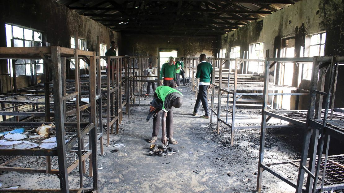 Students of St. Peter's-Nyamesocho in Kisii  rummage through a burned dormitory for salvageable items. 
